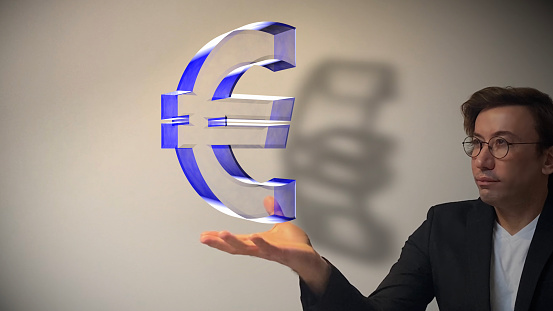 In the digitalizing world, the digitalization of the Euro, the reserve currency, is inevitable. Smart businessman showing next-generation hologram technology held in his hand. Augmented virtual reality is about to become a part of life in the near future. / You can see the animation movie of this image from my iStock video portfolio. Video number: 1443090656
