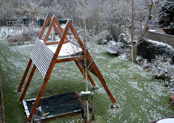 construction of a pergola shading the kindergarten playground with a sandpit. board battens are just the place where it is necessary to shield children playing, rooftop with strong beams screwed , screwed, pit