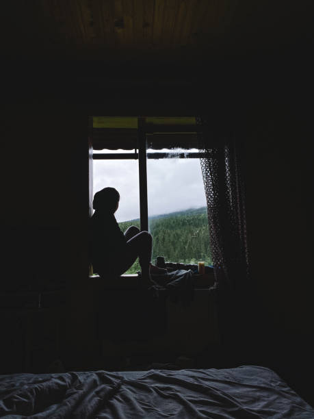 istock the girl is sitting on the windowsill 1444394967