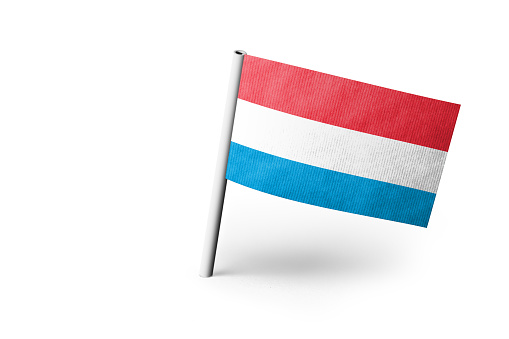 Small paper flag of Luxembourg pinned. Isolated on white background. Horizontal orientation. Close up photography. Copy space.