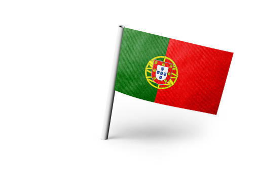Small paper flag of Portugal pinned. Isolated on white background. Horizontal orientation. Close up photography. Copy space.