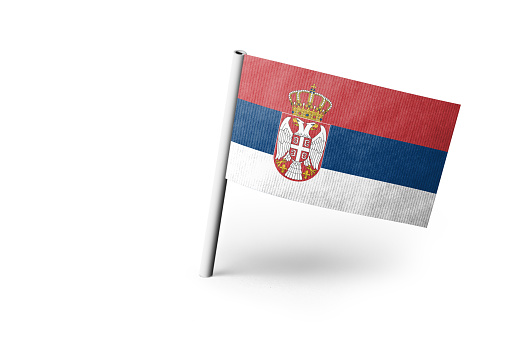 Small paper flag of Serbia pinned. Isolated on white background. Horizontal orientation. Close up photography. Copy space.