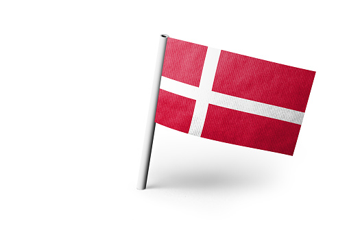 Small paper flag of Denmark pinned. Isolated on white background. Horizontal orientation. Close up photography. Copy space.