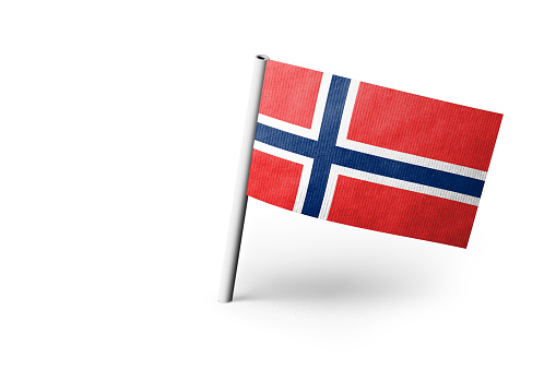 Small paper flag of Norway pinned. Isolated on white background. Horizontal orientation. Close up photography. Copy space.