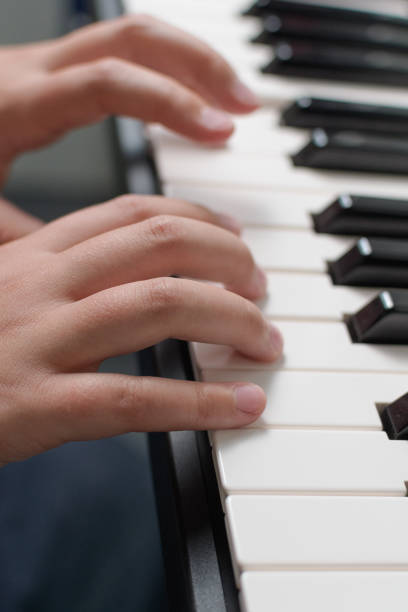 istock Music exercises. Piano two hands playing lessons. Keyboard close-up 1444398716