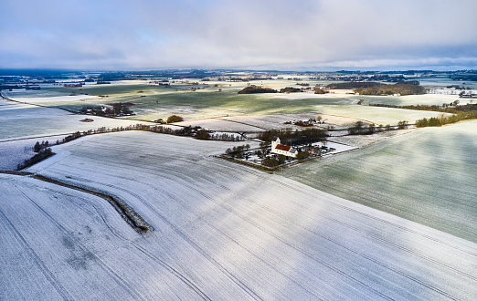 Frozen soil. Snow on the ploughed field. Winter landscape.