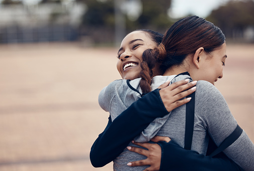 Fitness, hugging and friends with a sports woman and female athlete embracing during an exercise or workout routine. Motivation, training and achievement with sporty people in celebration of a goal