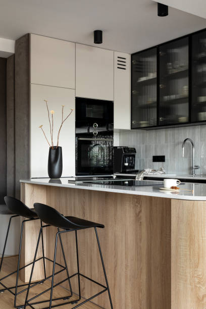 istock Modern composition of kitchen space with design kitchen island, black hookers, grey table, black vase with dried flowers, furnitures, and elegant personal accessories. Stylish home decor. Template. 1444402915