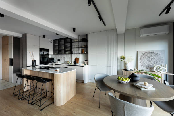 istock Modern composition of kitchen space with design kitchen island, black hookers, grey table, flowers, furnitures, big window and elegant personal accessories. Stylish home decor. Template 1444403048