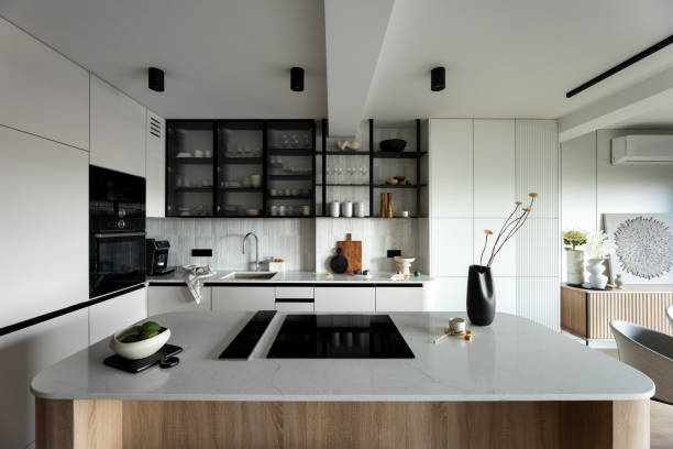 istock Modern composition of kitchen space with design kitchen island, grey table, black vase with flowers, furnitures and elegant personal accessories. Stylish home decor. Template. 1444403147