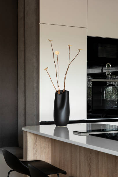 istock Modern composition of kitchen space with design kitchen island, design vase with dried flowers, black hookers, grey table, flowers, furnitures, big window and elegant personal accessories. Stylish home decor. Template. 1444403840