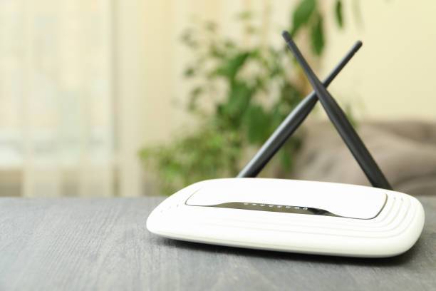 istock Wi-Fi router with external antennas on wooden table 1444405523