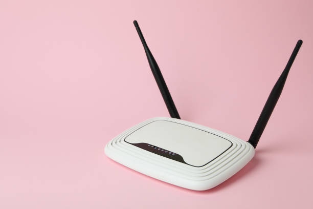istock Wi-Fi router with external antennas on pink background 1444405612