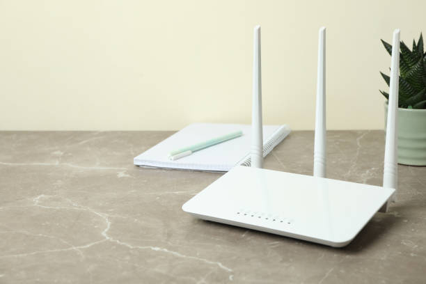 istock Workplace with Wi - fi router on gray textured table 1444405655