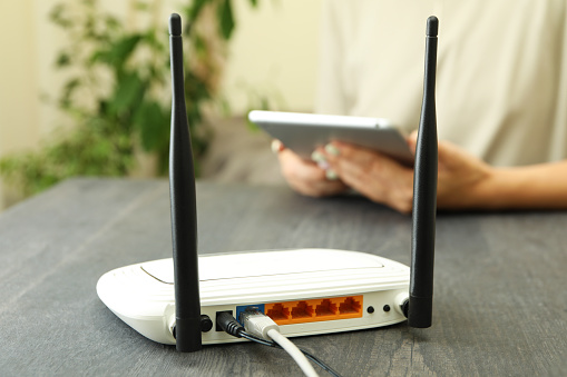 Wi - fi router on gray wooden table, close up