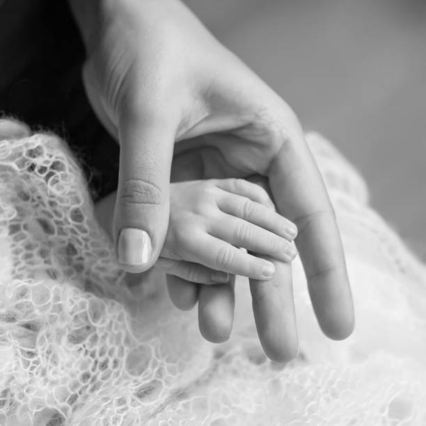 Newborn children's hand  in mother hand. Mom and her Child. Happy Family concept. Beautiful conceptual image of Maternity stock photo