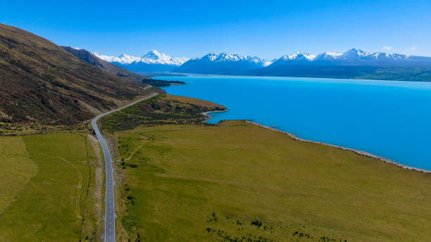 aerial view of landscape view of  mountain range near aoraki mount cook and the road leading to mount cook village in new zealand - zeeland imagens e fotografias de stock