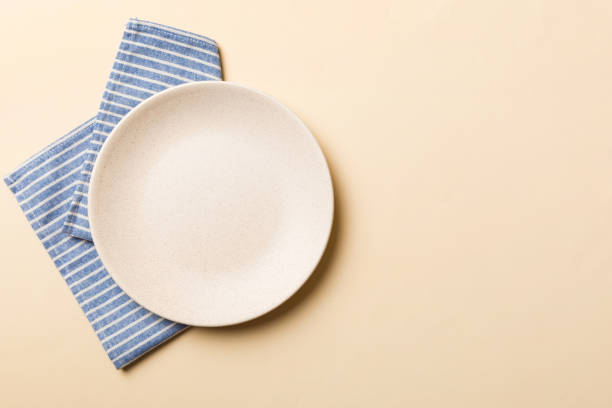 음식에 대 한 식탁보에 빈 둥근 흰색 접시에 색깔 배경에 대 한 상위 보기입니다. 디자인을위한 공간이있는 냅킨에 빈 접시 - table top shot 뉴스 사진 이미지