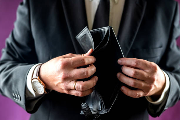 istock Close-up of a shocked man's hand holding an empty wallet without banknotes. 1444415888