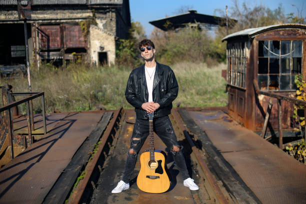 Young male musician posing with his acoustic guitar. About 25 years old, Caucasian man.