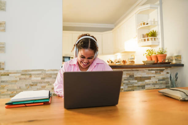 istock African girl using laptop computer at home while working on school project - Focus on face 1444419993