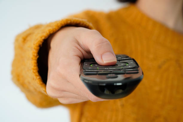 istock unrecognizable woman changing channel with remote control at home 1444422572