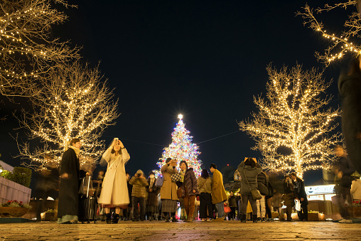 Tokyo, Japan - December 23, 2019: Big outdoor Christmas tree and people in Yebisu Garden Place.