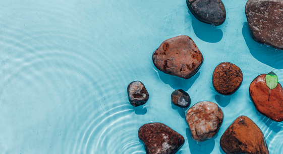 Sea stones in the sea water. Pebbles under water. Top view. Stones In Blue Water - Zen Concept