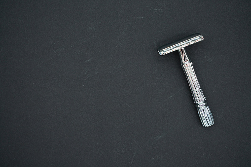 T-shaped razor on a black background. Top view. Place for text.
