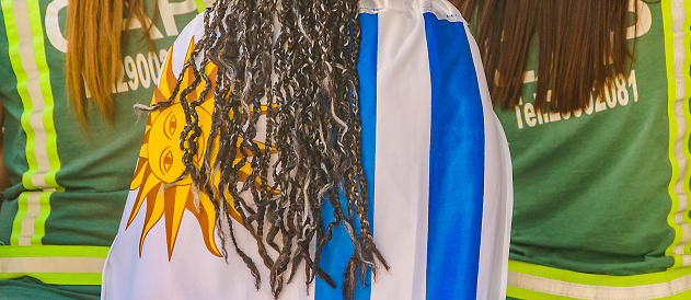 Montevideo, Uruguay - November 24, 2022: Back view women at street watching uruguay versus corea world cup soccer match