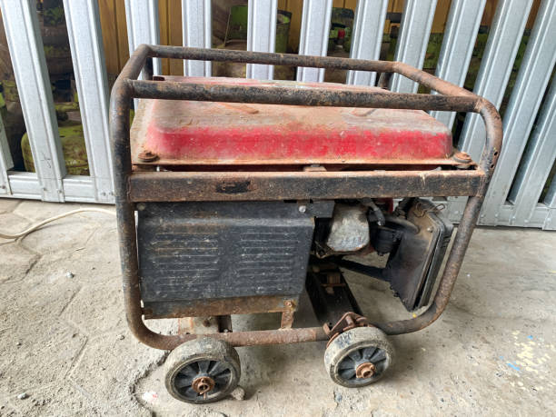 Portable power generator rusty in the warehouse. Compact equipment for powering various devices in nature and in places without power supply
