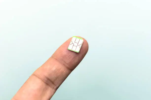 Close up Nano SIM card on finger. Telecoms concept, nanotechnology.