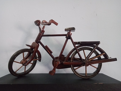a miniature bicycle made of wood and suitable as a wall decoration