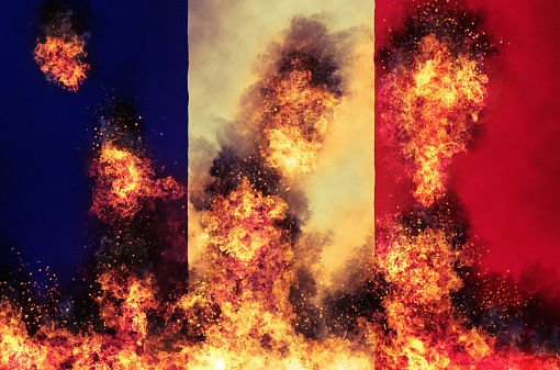 Fire and flames consume the national flag of France.