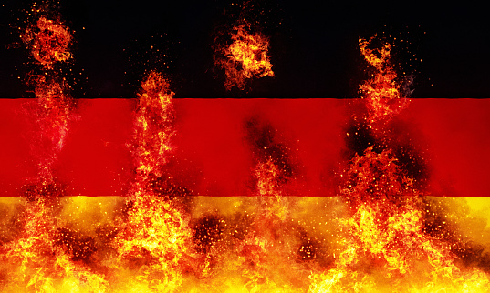 Fire and flames consume the national flag of Germany.