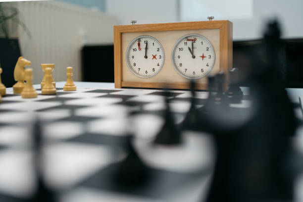 close-up of a classical chess board with playing pieces and mechanical chess clock