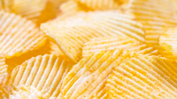 istock Yellow crispy ridged potato chips close up. Food background 1444457294