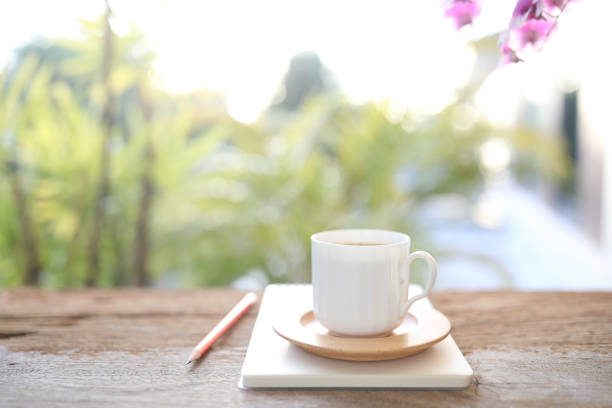 istock Coffee cup and notebook and pencil on wooden table 1444459425