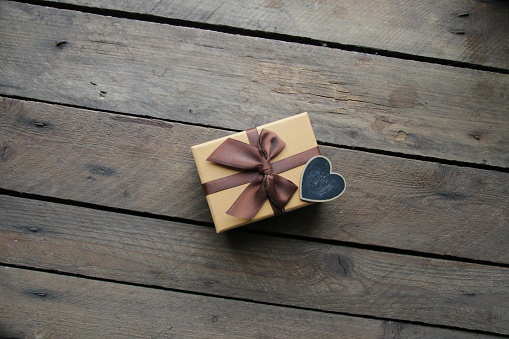 Vintage gift box with bow on wooden background