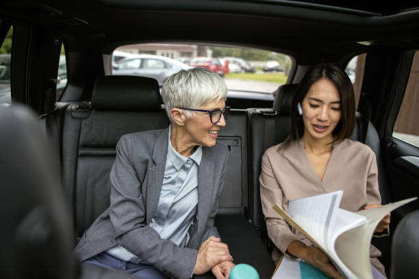 istock Businesswoman and her assistant checking documents while traveling to work 1444464308