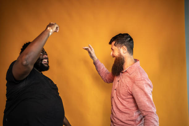 Male friends dancing on an orange background
