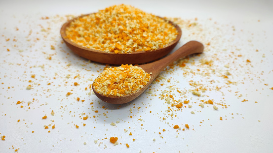 Panir Flour or Bread Crumbs in yellow and white colors on a wooden bowl, on a white isolated background. Selective focus, copy space.
