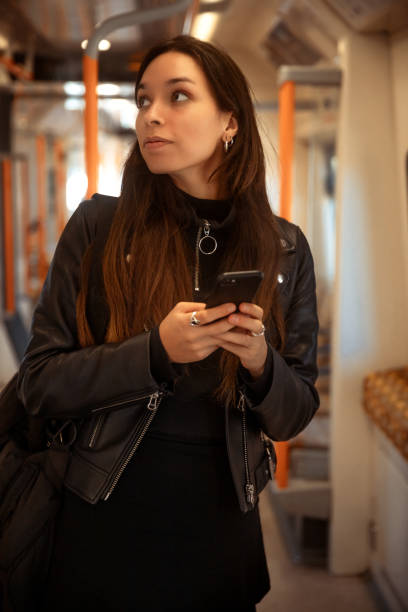 istock Woman on metro train using smartphone 1444469012