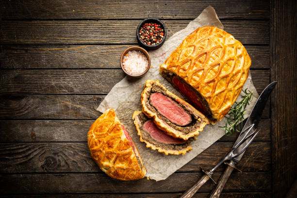 Perfect homemade Beef Wellington Perfect homemade juicy Beef Wellington, tenderloin dish on rustic wooden table, top view celebrity roast stock pictures, royalty-free photos & images