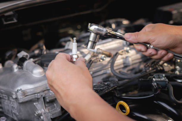 istock Technician holding gasoline engine spark plug in hand and a wrench to disassemble and maintain in the garage.service cycle of engine maintenance fix problems caused by abnormal operation of engine 1444474807