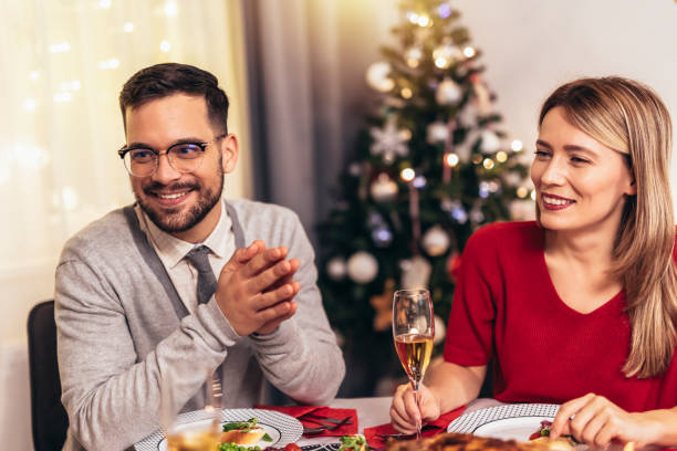 istock Couple drinking wine and laughing while sitting around a dining table during a dinner party 1444475018
