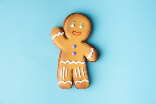 istock Gingerbread man decorated with white icing isolated on the blue pastel background. Flat lay. Traditional homemade Christmas cookies. Copy space 1444482275