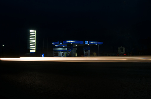 Modern gas station with convenience store beside the road at night. Blackout. Ukraine