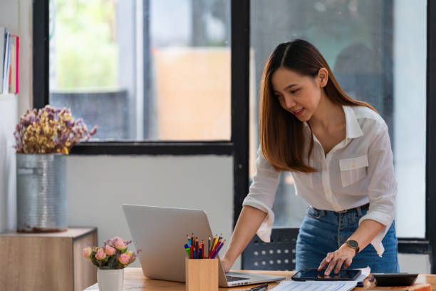 istock Beautiful Asian businesswoman work using a tablet and a laptop with documents placed at the office. 1444484809