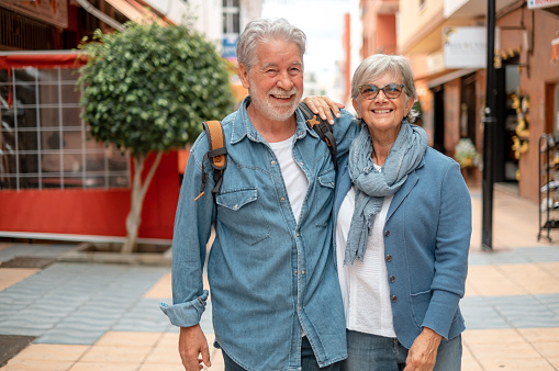 Happy smiling senior couple of tourist walking in the city. Attractive white haired caucasian people enjoying free time or retirement